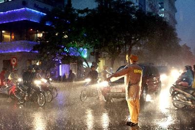 A traffic policeman guides traffic at a crossroad during a heavy downpour in Hanoi in June (File photo: VNA)